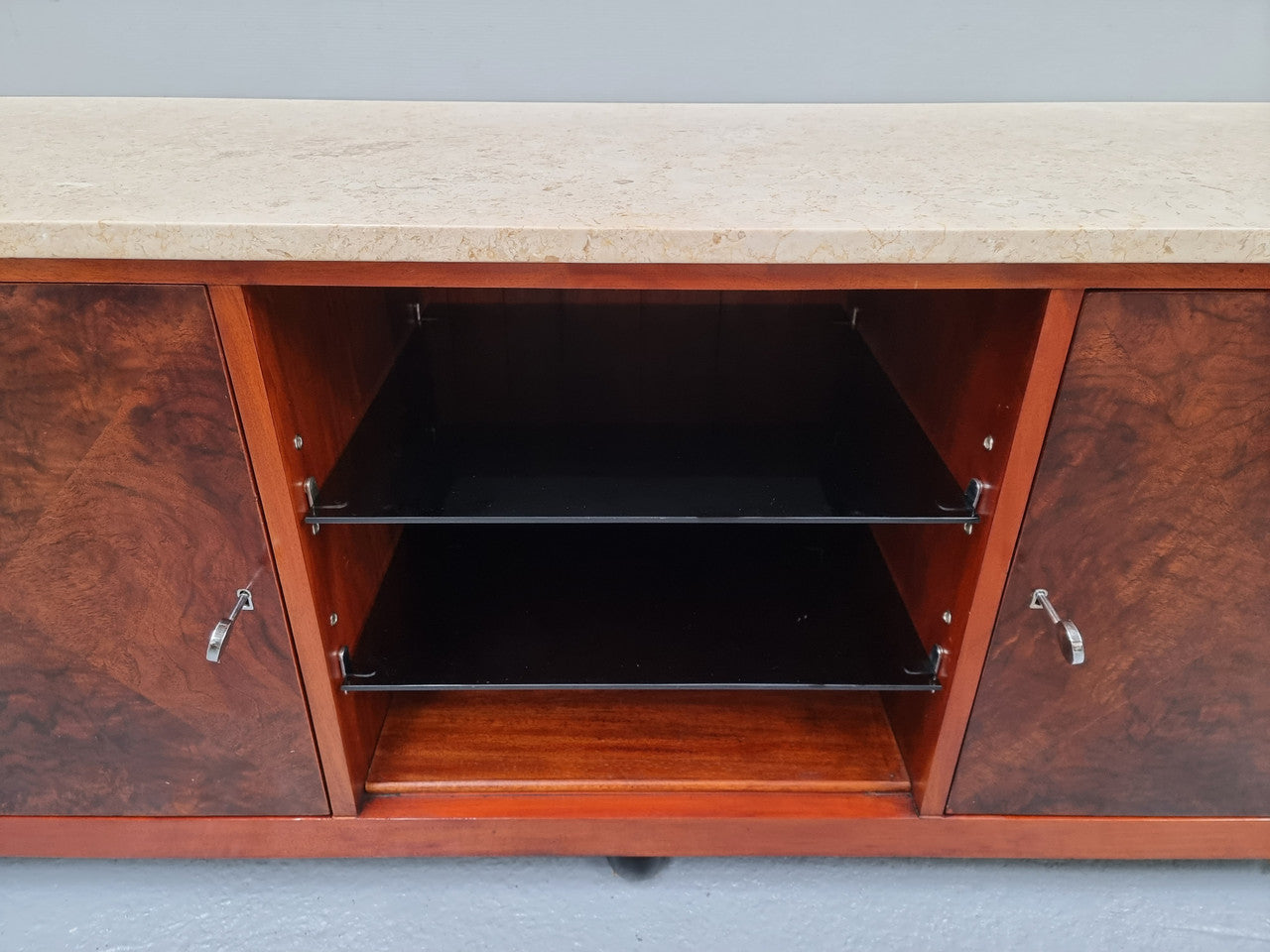 Beautiful Bespoke Art Deco style walnut and mahogany low line cabinet with a marble top and plenty of storage. It has two doors with a shelf each side and in the middle in has two glass shelves. Would make an ideal TV cabinet and has a hole in the back to run cords through. In very good original detailed condition.