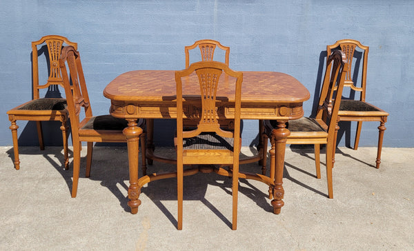 Beautiful carved French Oak dining table with a parquetry top and six matching upholstered chairs. All in good original detailed condition.