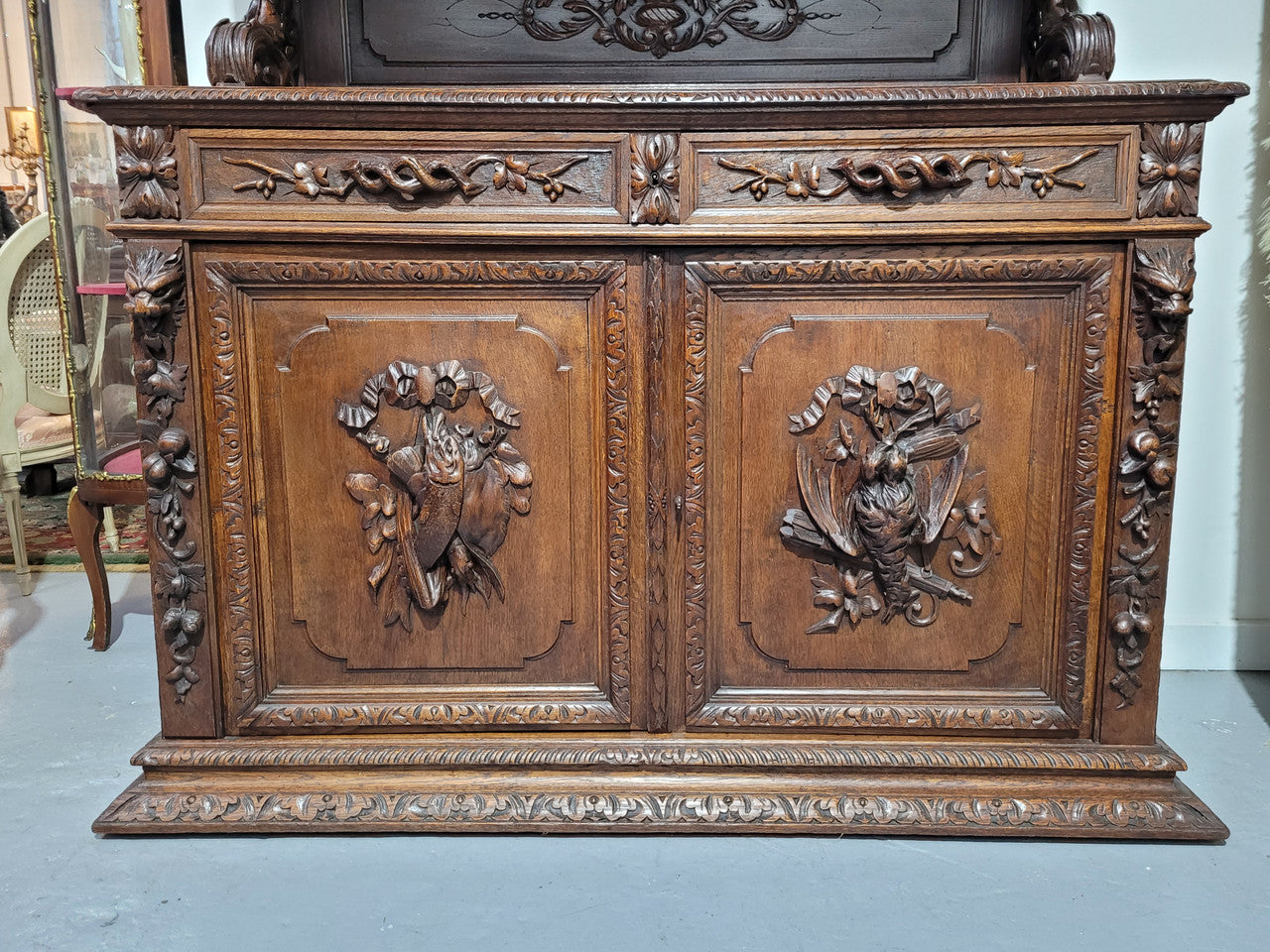 Grand French Oak Gothic style buffet with amazing detailed carvings. This stunning buffet has a display section at the top with two adjustable shelves, two drawers in the middle with elegantly carved handles and storage below with one fixed shelf. It is in good original detailed condition.