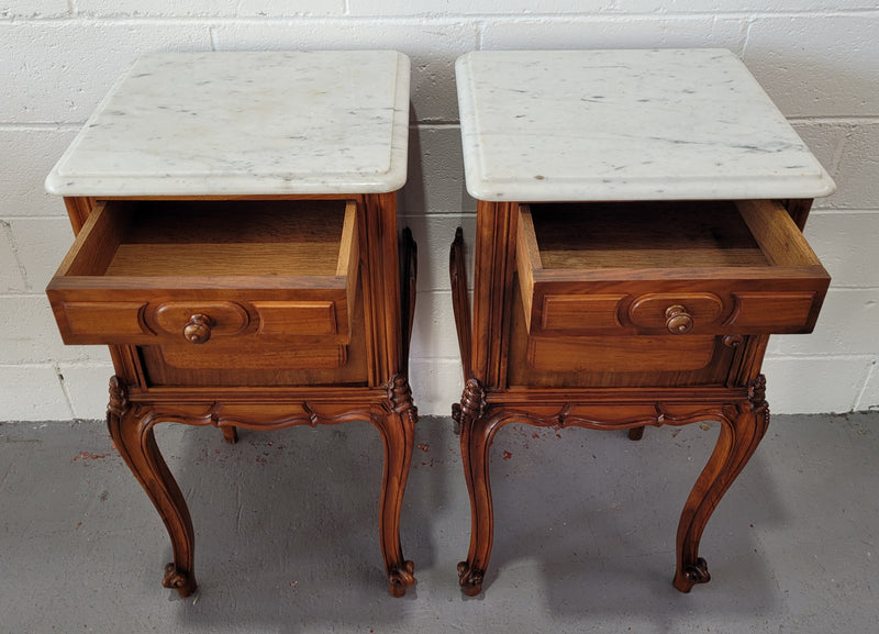 Pair of stunning Louis XV style French Walnut white marble top bedside cabinets. They have one drawer and a cupboard that is marble lined. The marble has been polished and they are in good original detailed condition.