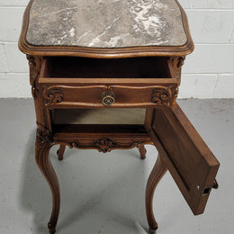Beautiful French Walnut carved bedside cabinet with a lovely grey coloured inset marble top. The inside of the cupboard is also marble lined and it is in good original detailed condition.
