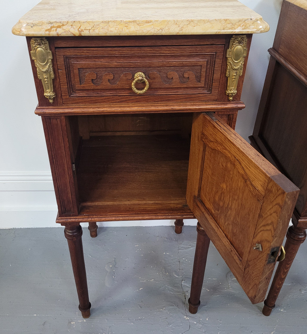 French Oak pair of Louis 16th style marble top bedsides with stunning bronze mounts. They have been sourced from France and are in good original detailed condition.