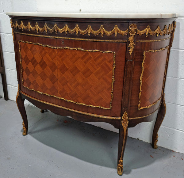 Vintage French style marble top two door half-moon buffet with beautiful decorative brass gilt mounts. In good original detailed condition.