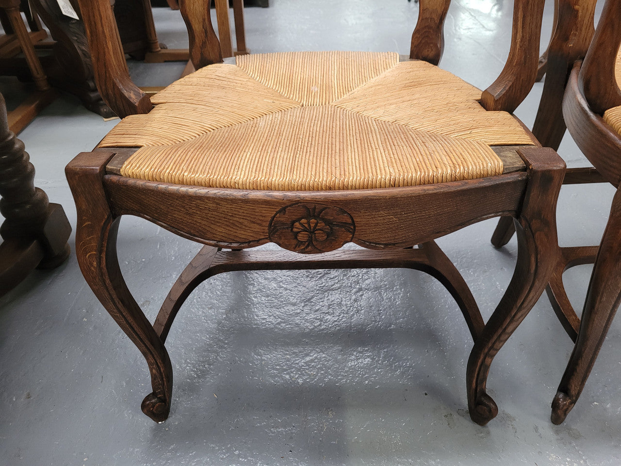 Pair of Louis XV Style Oak framed rush seated carver chairs. They have been sourced from France and in good original detailed condition.