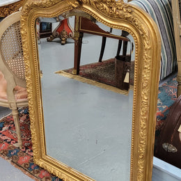 Beautiful French Napoleon III Louis XV style gilt framed bevelled mirror with an ornate crest on top. It has been sourced from France and is in good original detailed condition with the mirror showing signs of age.