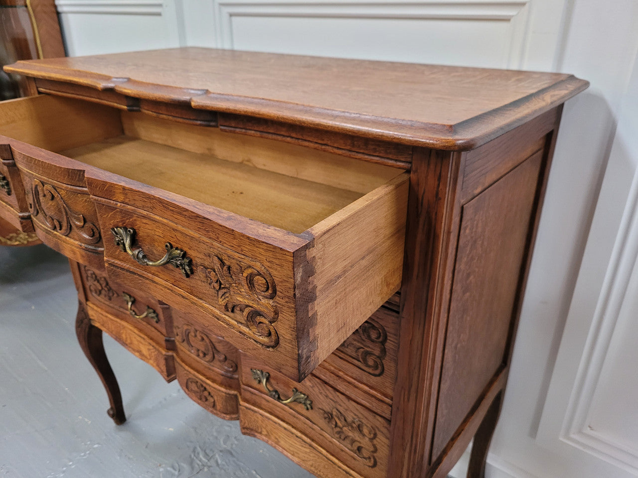 Vintage French dark Oak Louis XV style chest of three drawers. It has beautiful cabriole legs, elegant brass handles and decorative carving throughout. It is in good original detailed condition and has been sourced from France.