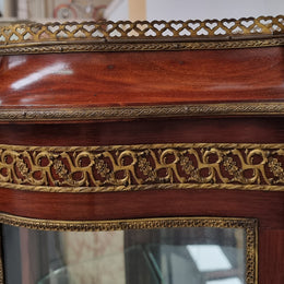 Beautiful French Louis XV style vitrine/ display cabinet with curved glass, gilt mounts, mirrored back and two glass shelves for your displays . It is in good original detailed condition.