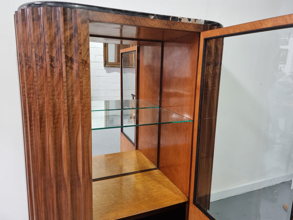 Stunning French Art Deco figured Walnut with Portoro marble top cocktail cabinet. Features chrome trim on base and glass display in door. It is in fully restored condition.