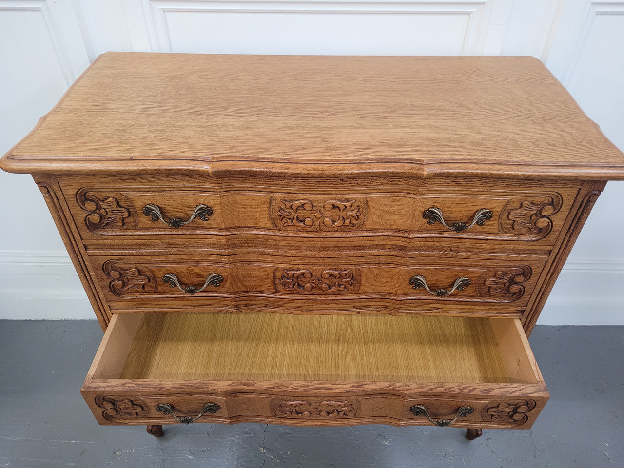 French Oak Louis 15th style nicely carved three drawer wooden top commode. It has been sourced from France and is in good original detailed condition.