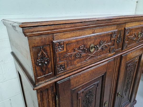 18th century French Oak Tall sideboard with beautiful carvings. It has plenty of storage with two drawers at the top and two doors at the bottom with a fixed shelf inside. It is in good restored condition.
