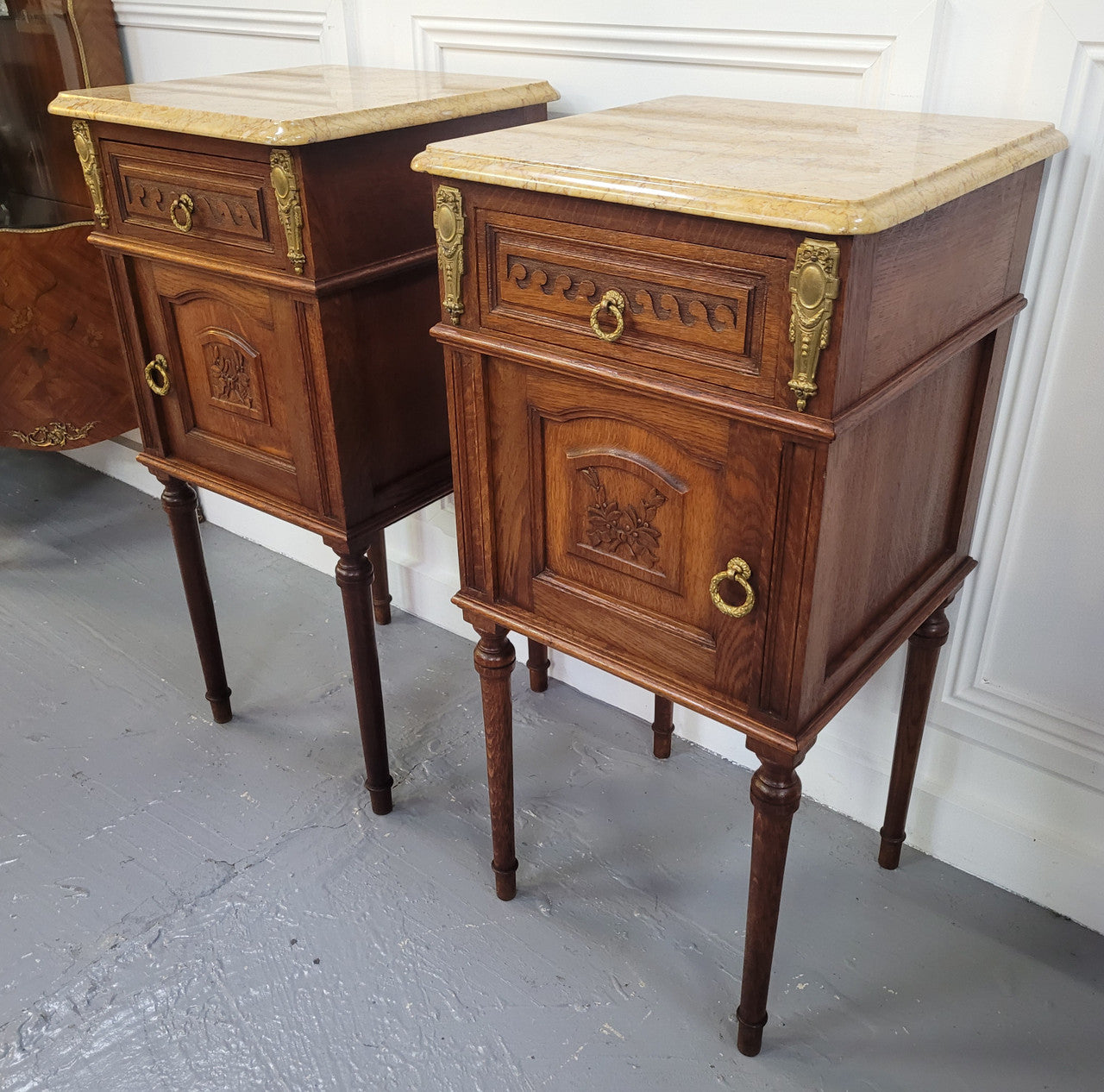 French Oak pair of Louis 16th style marble top bedsides with stunning bronze mounts. They have been sourced from France and are in good original detailed condition.