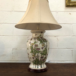 Contemporary ceramic lamp base decorated with daises & butterflies on a wooden base with shade.