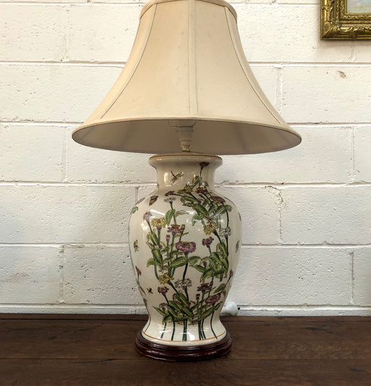Contemporary ceramic lamp base decorated with daises & butterflies on a wooden base with shade.