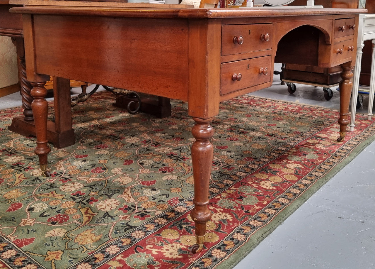 Australian Cedar full partners desk with attractive tooled leather top, four drawers either side and on caster wheels.  In good original detailed condition.