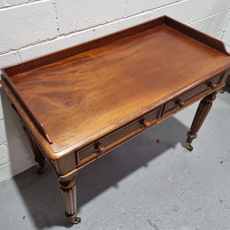 English Victorian Mahogany side table or desk with two drawers and gallery, fluted legs and ceramic castors. In good original condition.