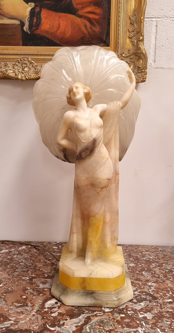 Monumental Art Deco alabaster and marble figural lamp modelled as a seductively dressed semi naked woman. In subtlety coloured diaphanous robes with a large clam shell light backdrop. Italian circa 1920's signed to base. This is a world class example of a true Art Deco sculpture lamp. It is in good original detailed condition, please view photos as they help form part of the description.