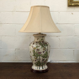 Contemporary ceramic lamp base decorated with daises & butterflies on a wooden base with shade.