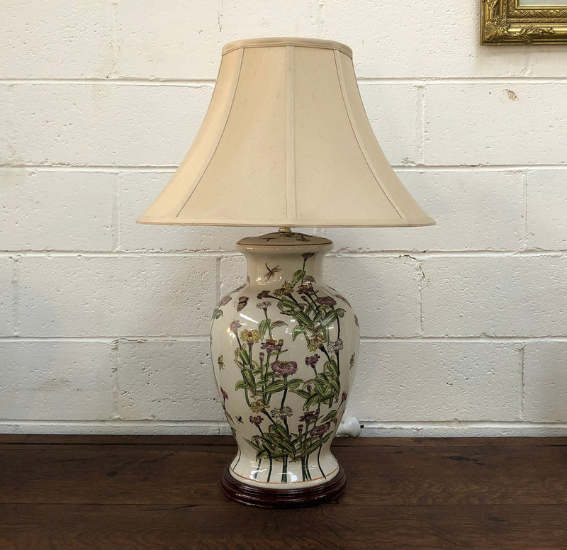 Contemporary ceramic lamp base decorated with daises & butterflies on a wooden base with shade.