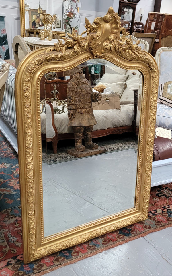 Beautiful French Napoleon III Louis XV style gilt framed bevelled mirror with an ornate crest on top. It has been sourced from France and is in good original detailed condition with the mirror showing signs of age.
