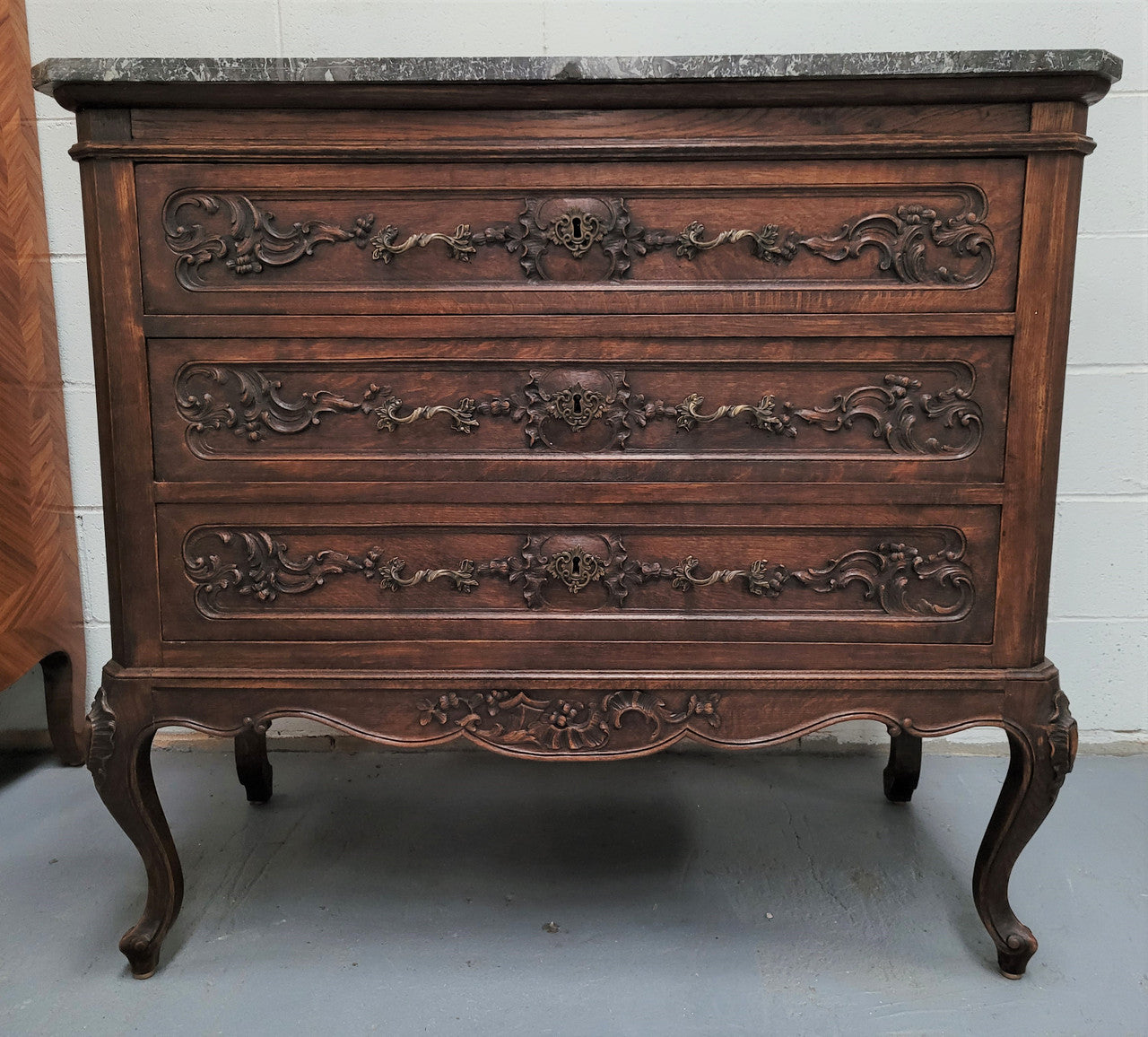 French Oak Louis XV style marble top chest of three drawers. It has beautiful carvings on the drawers with lovely decorative handles all toped with a stunning black and white marble top. In good original detailed condition.