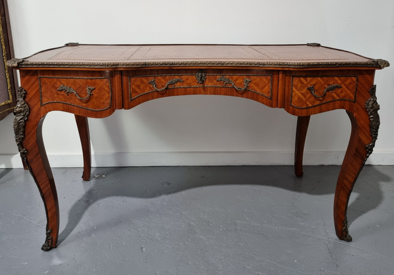 An impressive French kingwood and ormolu mounted bureau plat. It has a brown tooled leather writing surface, three decorated frieze drawers to the shaped apron with foliate swing handles and well cast figural mounts. Beautiful cabriole legs with decorative ormolu mounts and trims throughout. In good original detailed condition.