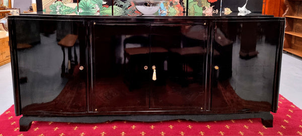 French Art Deco sideboard with a custom black lacquer finish.  Beautiful serpent shaped front with four cupboards with working locks and includes to working keys. It is in original condition.