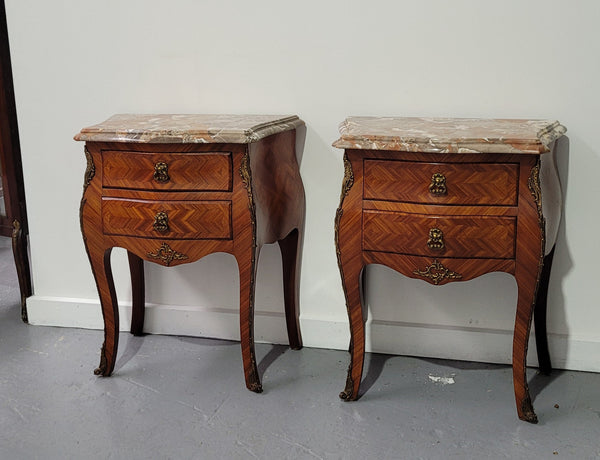Pair of Louis XV commode style two drawer bedsides with beautiful marble tops and decorative mounts. They are a rare size and are in good, detailed condition.
