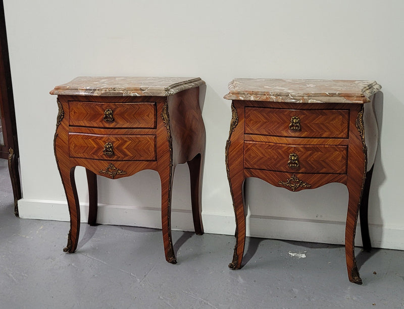 Pair of Louis XV commode style two drawer bedsides with beautiful marble tops and decorative mounts. They are a rare size and are in good, detailed condition.