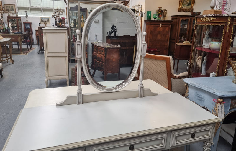 French Louis XVI style painted dresser / console with beveled oval mirror and three drawers. Sourced from France and in good original detailed condition.