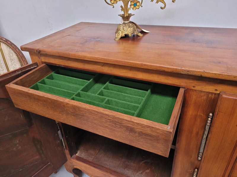 Early 19th Century Louis XV style Fruitwood three door sideboard. It has three hidden internal drawers and one of them has green valet and small sections for cutlery. It is in good restored condition.