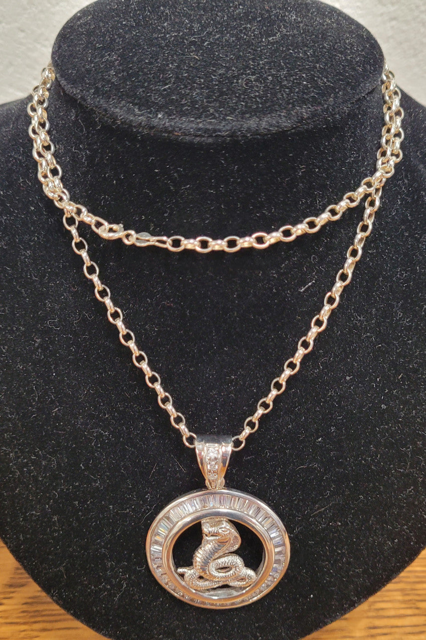 Sterling Silver pendant featuring a Cobra Snake with Cubic Zirconia surround. Heavy Bale with Cubic Zirconia. Pendant without Bale, 3.5cm Diameter. Includes 60 cm Sterling Silver Chain.