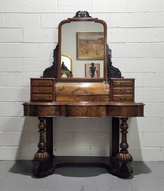 An elegant Victorian Figured Walnut dressing table with tilit mirror and a stunning fine Firgured Walnut serpentine shaped front. It has been sourced locally and is in good original detailed condition.