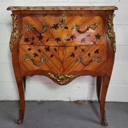Charming petite French Louis XV style commode featuring two drawers, marquetry inlay, ormolu trim and marble Top. In good original detailed condition.  Circa: 1930’s.
