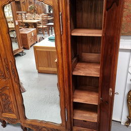 French Walnut Louis XV style three door armoire with 10 fully adjustable shelves in total spread over three sections, two drawers and a mirrored middle door. It has been sourced from France and in good original detailed condition.