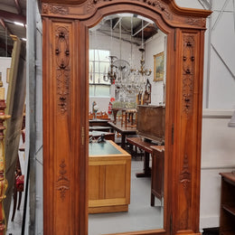 Imposing Louis XV style single mirrored door Walnut armoire. Features deep carved decoration, two interior drawers and three adjustable shelves. It is in good original detailed condition and has been sourced from France.