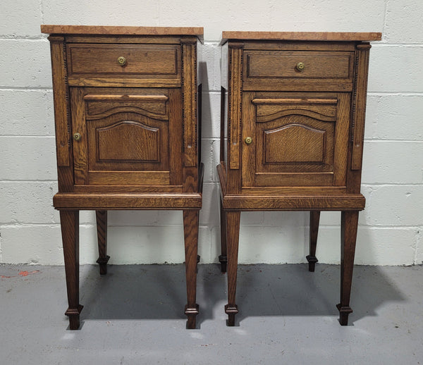 Beautiful pair of French oak bedside cabinets with marble tops. They have a drawer and cupboard for storage and are in good original detailed condition.