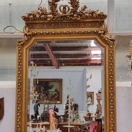 A stunning Napoleon III gilt mantle mirror with its original mirror. The top of the mirror is decorated with a beautiful laurel wreath and detailed decorative carving throughout. It is in good original condition with the bevelled mirror showing natural aging please view photo's.