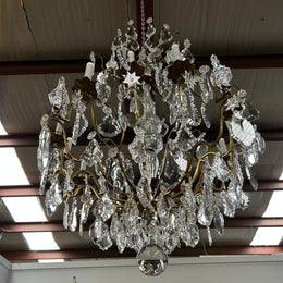 Louis XV 18th Century important cage shaped Castle Chandelier with 12 bronze scones and adorned with 8 daggers and large cut crystal prisms and the barrel threaded with cut glass pieces and finished with a large glass ball. The chandelier has beautiful proportions and is very well balanced in its arrangement of the crystals etc. The chandelier was sourced from Paris and comes with the majority of its original crystals intact. There are 6 internal lights and combined with the 12 sconces offers a dazzling arr