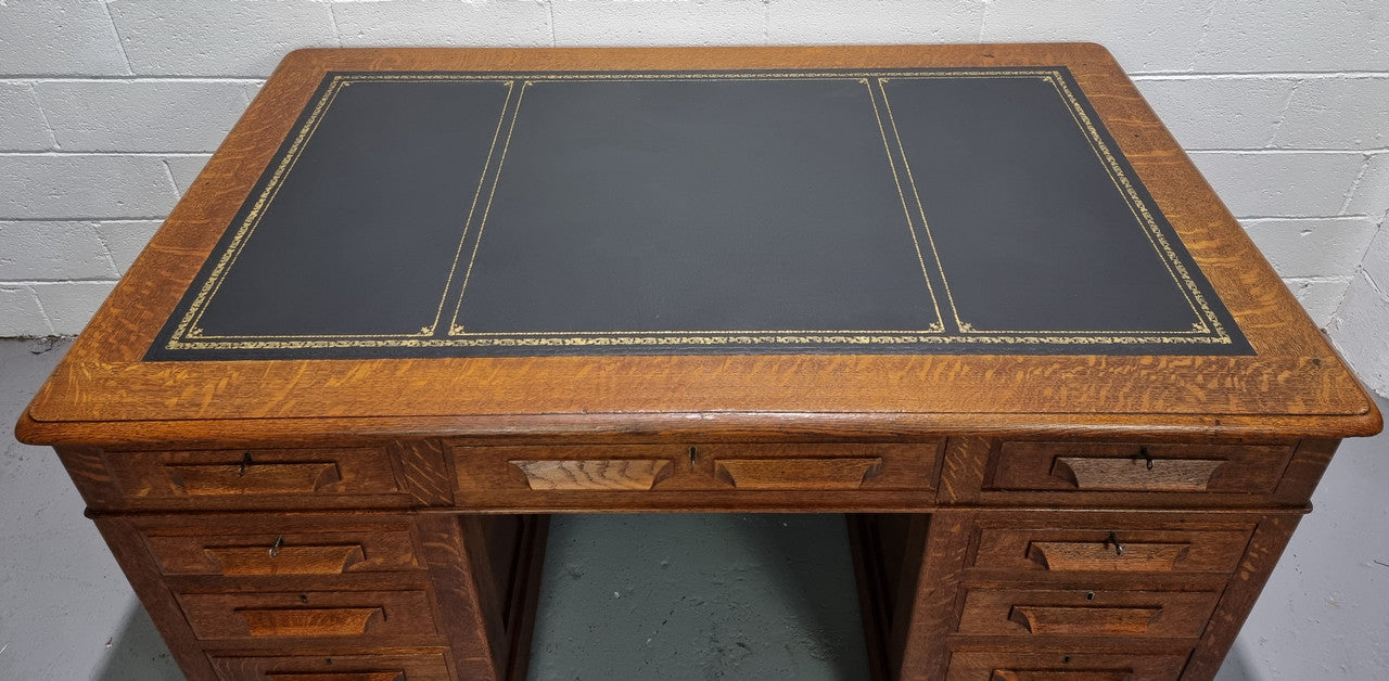 Amazing American Oak full partners leather top desk. Plenty of storage space with nine drawers on one side and two cupboards of the oppsite side. It is in good restored condition and has a new leather and gold tooled inset top.