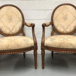 Pair of Antique French Louis XVI style carved Walnut fauteuils in restored condition. The Tapestry upholstery is in good condition some marks and wear but usable.