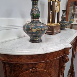 An elegant Antique Victorian Burr wood Walnut marble-top sideboard credenza with a mirrored center door. It has a white shaped marble top, mirror front, nicely carved details and three swing doors along with two keys. It is in good original detailed condition.