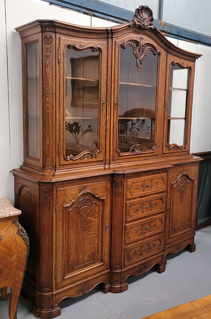 Impressive French Oak Louis 14th Style Display and Sideboard. It has 4 drawers, 2 bottom cupboards with 6 total shelves and 3 display doors with 3 shelves.  In good, detailed condition.