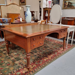 English Cedar full partners desk with attractive tooled leather top, four drawers either side and on caster wheels.  In good original detailed condition.
