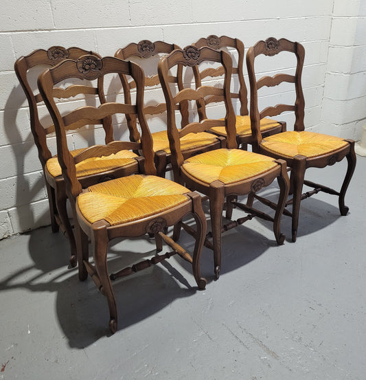 A set of 6 French Louis XV style oak dining chairs with rush seats in good original condition. All chairs have been detailed and re-glued where needed.