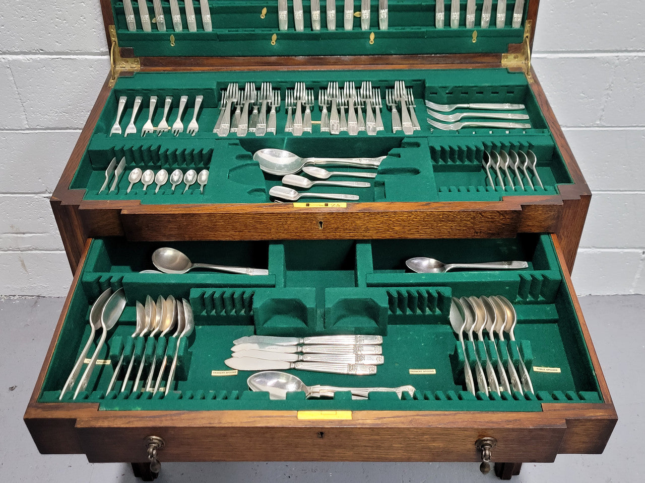 English Oak beautifully fitted cutlery table with a lift up top and drawer. Contains extensive silver plate part cutlery service by Elkington. In good original condition.