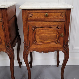 Pair of French Antique Louis XV style Oak marble top night stands. They have beautiful carved cabriole legs and beautiful white marble along with a drawer and cupboard for storage space. They have been sourced from France and are in good original detailed condition.