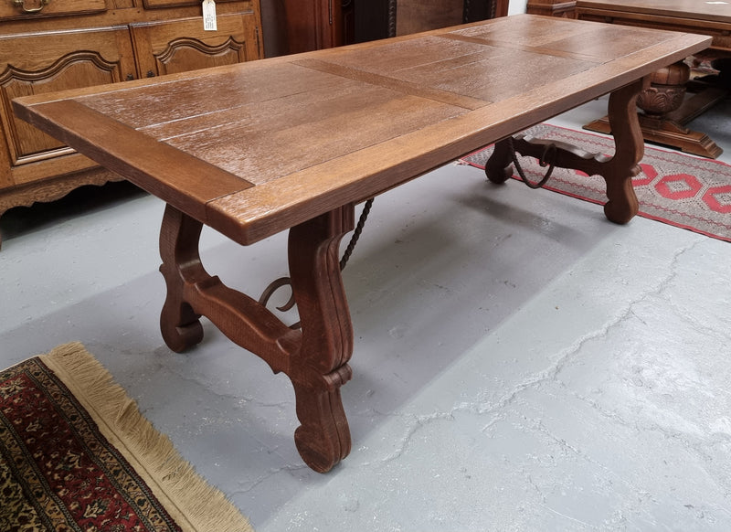 Purchased from France we have this amazing French Oak Spanish style farmhouse table featuring striking iron work underneath. It has been finished with an oil & wax finish making it more water resistant, stain resistant and durable then a natural wax finish. It can sit 6-8 people comfortable and is good restored condition.