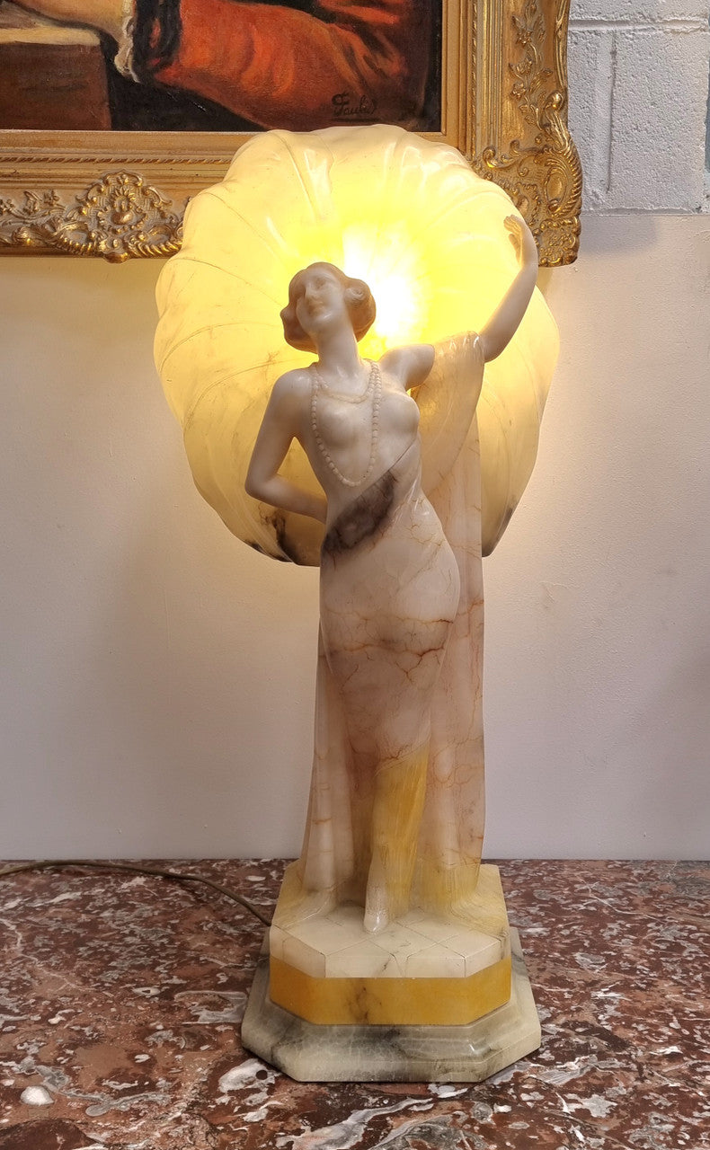 Monumental Art Deco alabaster and marble figural lamp modelled as a seductively dressed semi naked woman. In subtlety coloured diaphanous robes with a large clam shell light backdrop. Italian circa 1920's signed to base. This is a world class example of a true Art Deco sculpture lamp. It is in good original detailed condition, please view photos as they help form part of the description.