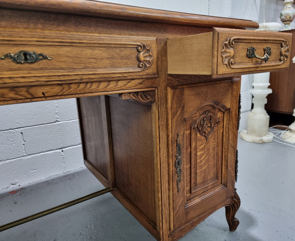 Fabulous French oak carved partners desk with a lovely parquetry top. It has three drawers and two cupboards on one side and two cupboards on the other side with no functioning drawers. It is in good original detailed condition.