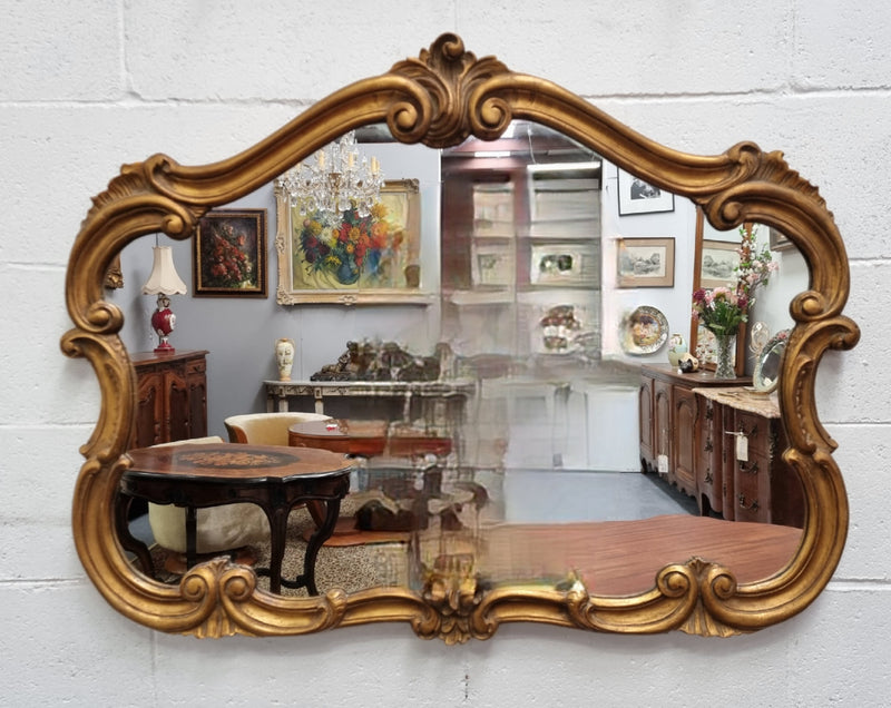 French Louis XV style wood carved and gilded mirror. Mirror is original and showing signs of age. It has been sourced from France and  in good original condition.